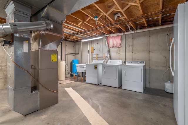 31688 Colon Rd, Colon, MI 49040 - unfinished below grade area with washing machine and clothes dryer, heating unit, a water softener system, and a water pressure tank