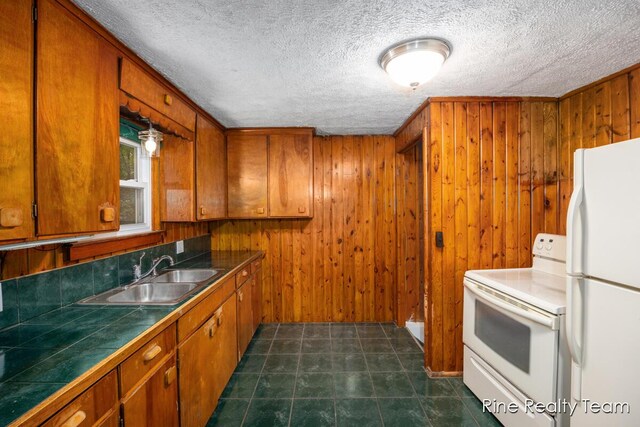 757 E Sidney Rd, Stanton, MI 48888 - kitchen featuring white appliances, brown cabinets, tile countertops, a textured ceiling, and wood walls