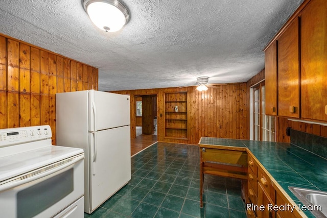757 E Sidney Rd, Stanton, MI 48888 - kitchen with white appliances, wooden walls, tile counters, brown cabinets, and a textured ceiling