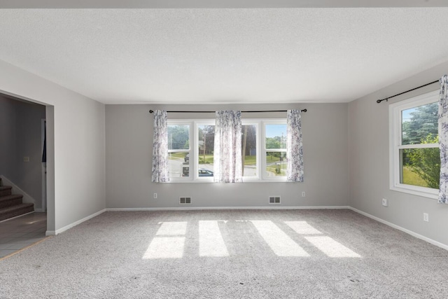 2647 Manitoba Ct NE, Grand Rapids, MI 49525 - empty room featuring carpet floors, plenty of natural light, a textured ceiling, and stairs