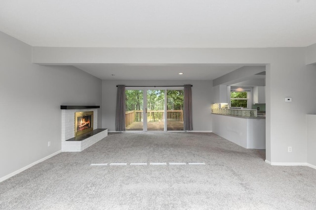 2647 Manitoba Ct NE, Grand Rapids, MI 49525 - unfurnished living room with carpet floors, a brick fireplace, and plenty of natural light
