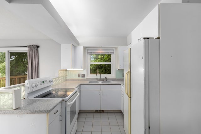 2647 Manitoba Ct NE, Grand Rapids, MI 49525 - kitchen with white appliances, light tile patterned floors, white cabinetry, light countertops, and a peninsula