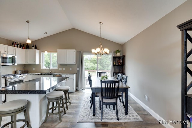 4284 Ives Farm Ln NE, Cedar Springs, MI 49319 - dining room featuring a chandelier, lofted ceiling, and light wood-style flooring