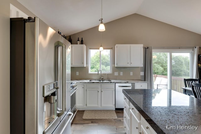 4284 Ives Farm Ln NE, Cedar Springs, MI 49319 - kitchen featuring appliances with stainless steel finishes, vaulted ceiling, light wood-style floors, white cabinets, and decorative light fixtures
