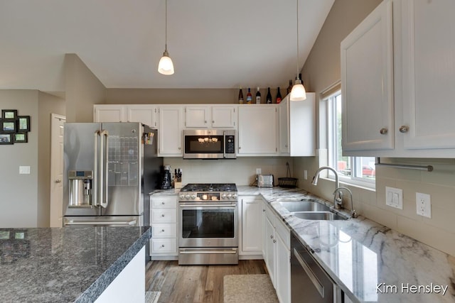 4284 Ives Farm Ln NE, Cedar Springs, MI 49319 - kitchen with appliances with stainless steel finishes, white cabinetry, tasteful backsplash, light wood-type flooring, and hanging light fixtures
