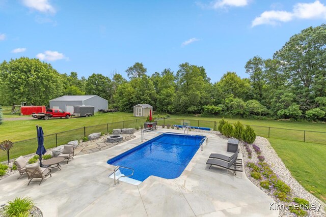 4284 Ives Farm Ln NE, Cedar Springs, MI 49319 - view of pool with an outdoor fire pit, a fenced backyard, a storage shed, a patio area, and view of wooded area