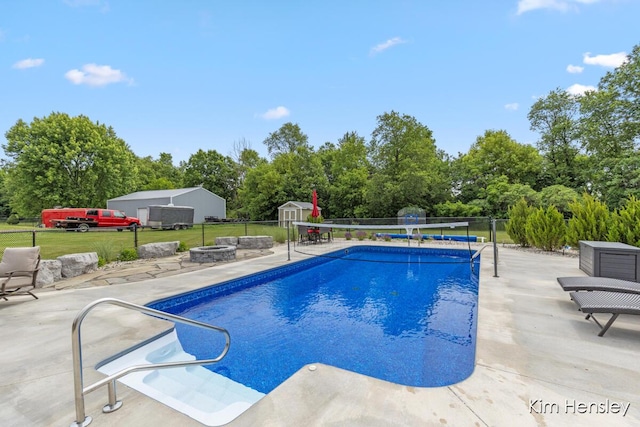 4284 Ives Farm Ln NE, Cedar Springs, MI 49319 - view of pool with a shed, a patio area, an outdoor fire pit, and view of wooded area