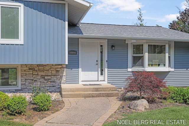 16093 Harbor Point Dr, Spring Lake, MI 49456 - doorway to property with board and batten siding, stone siding, and a shingled roof