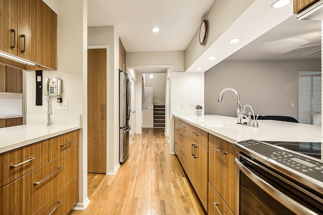 22 Haverhill Ct, Ann Arbor, MI 48105 - kitchen with stainless steel appliances, recessed lighting, light wood-type flooring, light countertops, and brown cabinetry