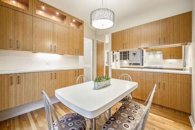 22 Haverhill Ct, Ann Arbor, MI 48105 - kitchen with backsplash, light wood-style floors, glass insert cabinets, and light countertops