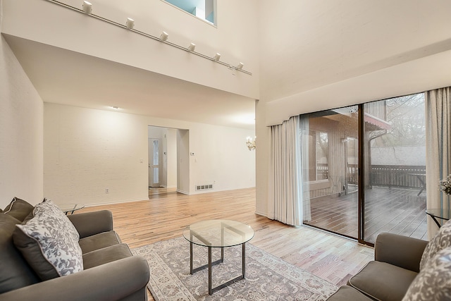 22 Haverhill Ct, Ann Arbor, MI 48105 - living area featuring light wood-style floors, a high ceiling, and healthy amount of natural light