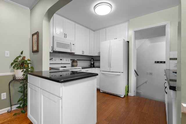 22836 Wellington St, Dearborn, MI 48124 - kitchen featuring white appliances, wood finished floors, dark countertops, backsplash, and white cabinets