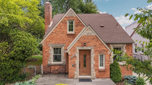 22836 Wellington St, Dearborn, MI 48124 - english style home featuring a chimney and a shingled roof