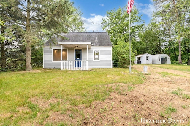 4578 135th Ave, Hamilton, MI 49419 - view of front of property featuring roof with shingles, a porch, a front yard, and an outbuilding