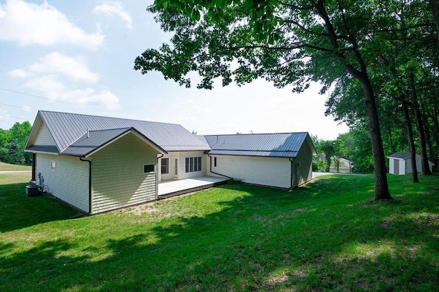 5412 Blackberry Ln, Coloma, MI 49038 - back of house featuring a metal roof, a lawn, and a storage shed