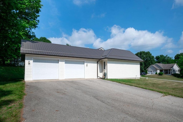5412 Blackberry Ln, Coloma, MI 49038 - view of front of house with a metal roof, a front lawn, a garage, and driveway