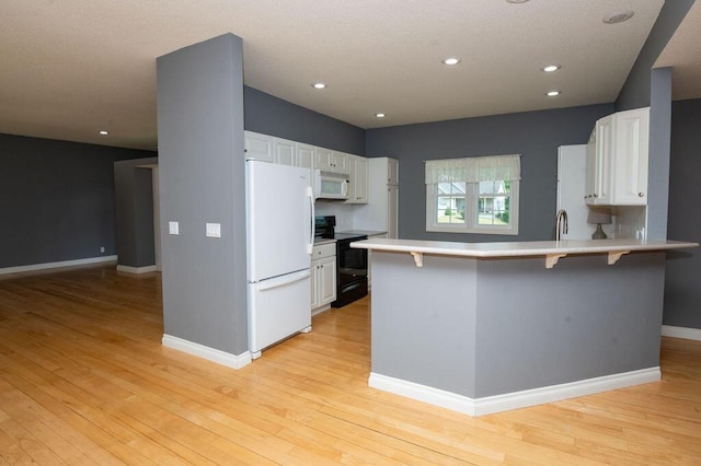 5412 Blackberry Ln, Coloma, MI 49038 - kitchen with white appliances, a peninsula, white cabinets, light countertops, and recessed lighting