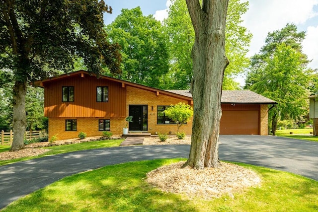 4330 Eastgate Dr, Ann Arbor, MI 48103 - tri-level home with asphalt driveway, brick siding, and an attached garage