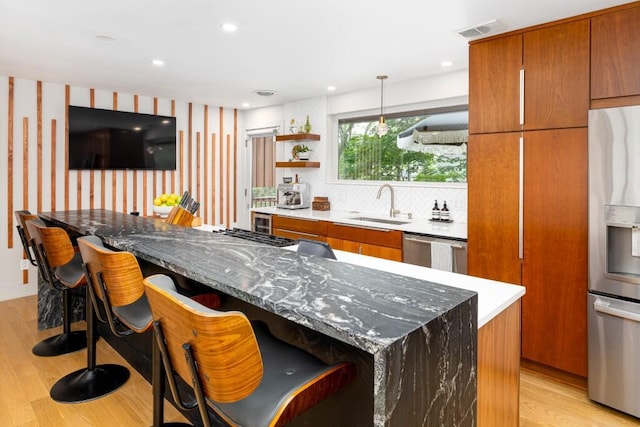 4330 Eastgate Dr, Ann Arbor, MI 48103 - kitchen featuring stainless steel appliances, light wood-style floors, brown cabinets, and recessed lighting