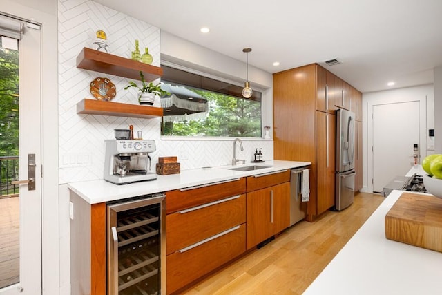 4330 Eastgate Dr, Ann Arbor, MI 48103 - kitchen with wine cooler, stainless steel appliances, backsplash, light wood-style floors, and light countertops