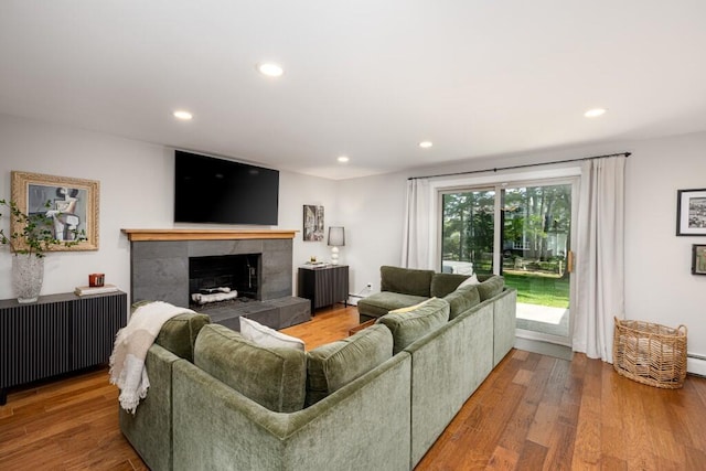 4330 Eastgate Dr, Ann Arbor, MI 48103 - living area with recessed lighting, wood finished floors, a tiled fireplace, and radiator heating unit