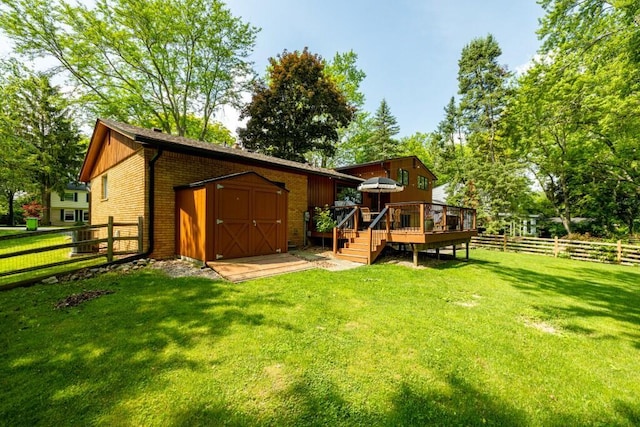 4330 Eastgate Dr, Ann Arbor, MI 48103 - rear view of property featuring a wooden deck, a storage unit, a fenced backyard, and brick siding
