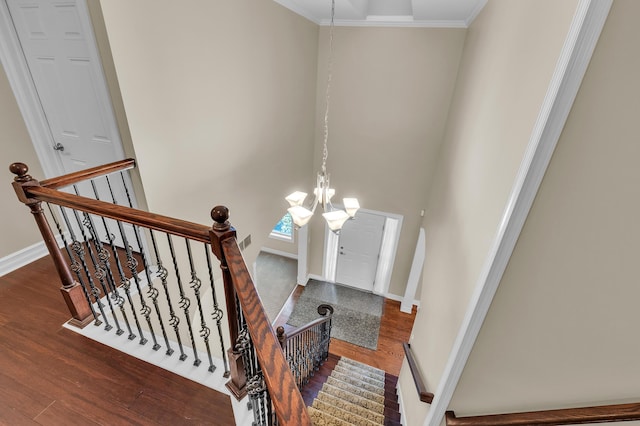 50501 Elmwood Ct, Plymouth, MI 48170 - stairway featuring wood finished floors, a chandelier, ornamental molding, and a high ceiling