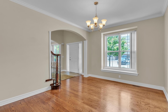 50501 Elmwood Ct, Plymouth, MI 48170 - empty room featuring arched walkways, a chandelier, wood finished floors, and crown molding