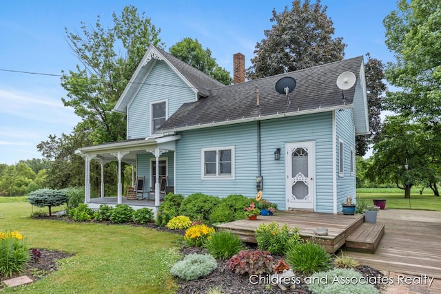 13872 Hastings Rd, Freeport, MI 49325 - back of property with a lawn, a chimney, a porch, and roof with shingles