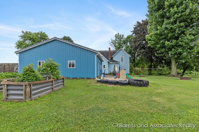 13872 Hastings Rd, Freeport, MI 49325 - rear view of property with a vegetable garden and board and batten siding