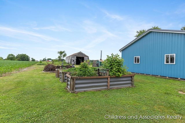 13872 Hastings Rd, Freeport, MI 49325 - view of green lawn featuring a vegetable garden and an outdoor structure