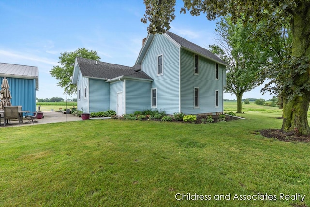 13872 Hastings Rd, Freeport, MI 49325 - back of property featuring a patio area, a yard, a chimney, and a shingled roof