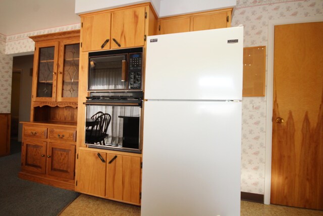 6426 Westchester St, Portage, MI 49024 - kitchen featuring black appliances, wallpapered walls, and glass insert cabinets