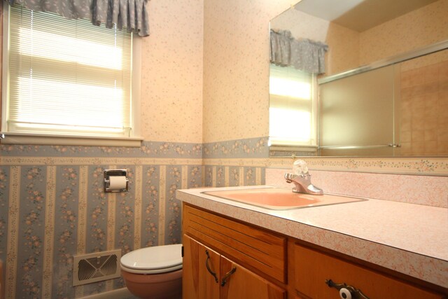 6426 Westchester St, Portage, MI 49024 - bathroom with vanity, healthy amount of natural light, wallpapered walls, and an enclosed shower