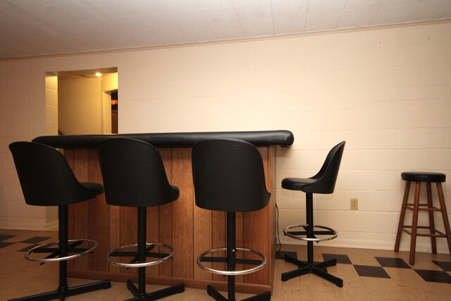 6426 Westchester St, Portage, MI 49024 - indoor dry bar featuring light floors, concrete block wall, and ornamental molding