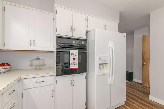 1736 Glenvale Dr SW, Wyoming, MI 49519 - kitchen featuring white refrigerator with ice dispenser, black oven, white cabinets, wood finished floors, and light countertops