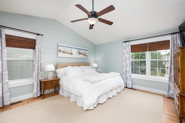 7149 Indian Wells Dr, Ypsilanti, MI 48197 - bedroom featuring lofted ceiling, light wood finished floors, wood walls, and a ceiling fan