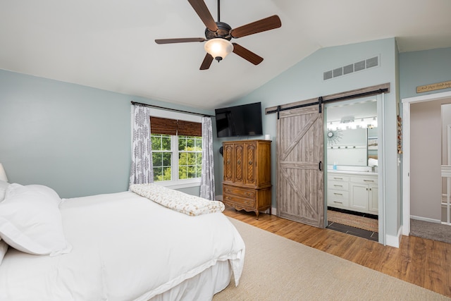 7149 Indian Wells Dr, Ypsilanti, MI 48197 - bedroom with a barn door, vaulted ceiling, wood finished floors, connected bathroom, and ceiling fan