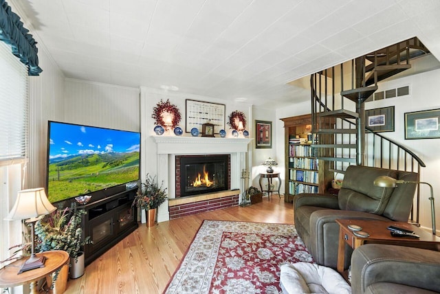 8454 Stickles Rd, Three Oaks, MI 49128 - living area with wood finished floors, stairway, and a brick fireplace