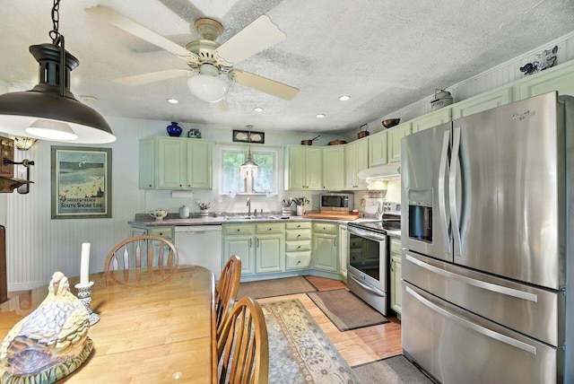 8454 Stickles Rd, Three Oaks, MI 49128 - kitchen with stainless steel appliances, green cabinets, light wood finished floors, pendant lighting, and a textured ceiling