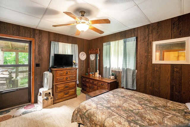 4424 Teal Ln, Newaygo, MI 49337 - bedroom with wooden walls, multiple windows, a ceiling fan, and light carpet