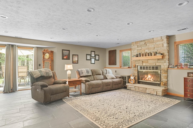 4792 Forest Vale Dr, Pierson, MI 49339 - living area with a stone fireplace, a textured ceiling, and recessed lighting