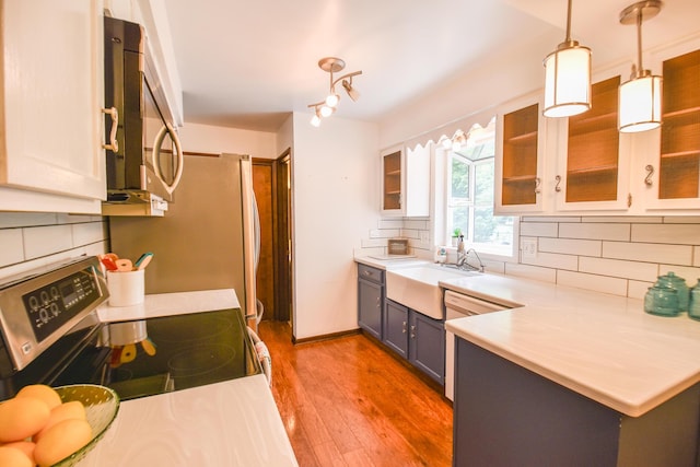 72 Branch Ave, Coldwater, MI 49036 - kitchen with appliances with stainless steel finishes, wood finished floors, decorative backsplash, light countertops, and a peninsula