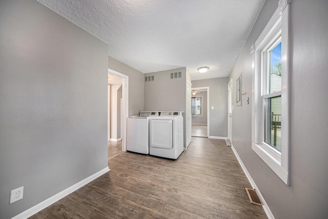 1836 W Argus Ct, Jackson, MI 49203 - laundry area featuring washer and dryer, plenty of natural light, wood finished floors, and a textured ceiling