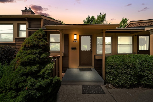 2834 Pittsfield Blvd, Ann Arbor, MI 48104 - exterior entry at dusk featuring a chimney