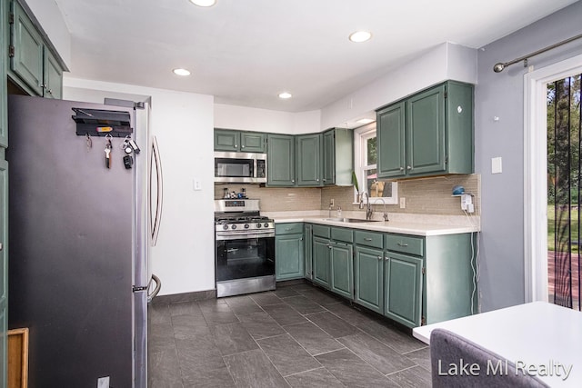 4128 Michael Ave SW, Wyoming, MI 49509 - kitchen with appliances with stainless steel finishes, green cabinetry, light countertops, backsplash, and recessed lighting