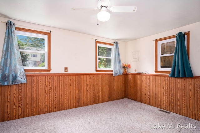 4128 Michael Ave SW, Wyoming, MI 49509 - carpeted empty room with a wainscoted wall, a ceiling fan, and wooden walls