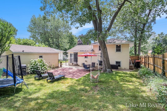 4128 Michael Ave SW, Wyoming, MI 49509 - rear view of property featuring a trampoline, a patio area, and a shingled roof