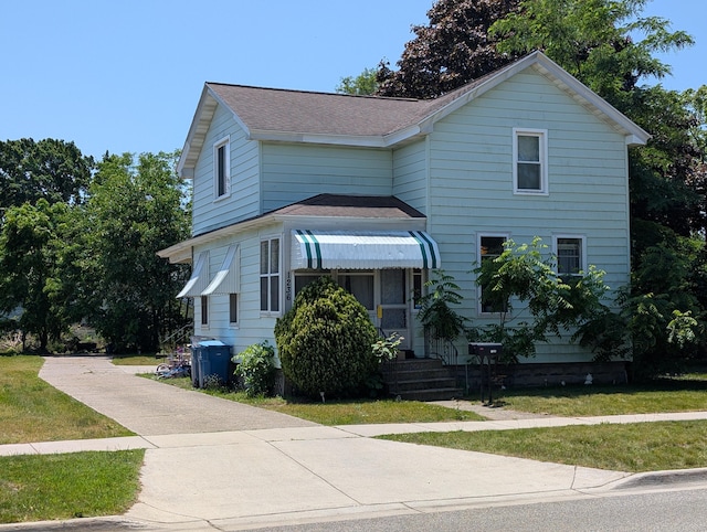 1236 Fulton Ave, Grand Haven, MI 49417 - traditional-style house featuring roof with shingles and a front yard