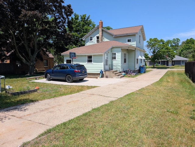 1236 Fulton Ave, Grand Haven, MI 49417 - view of front of house with concrete driveway, a chimney, a front yard, and roof with shingles